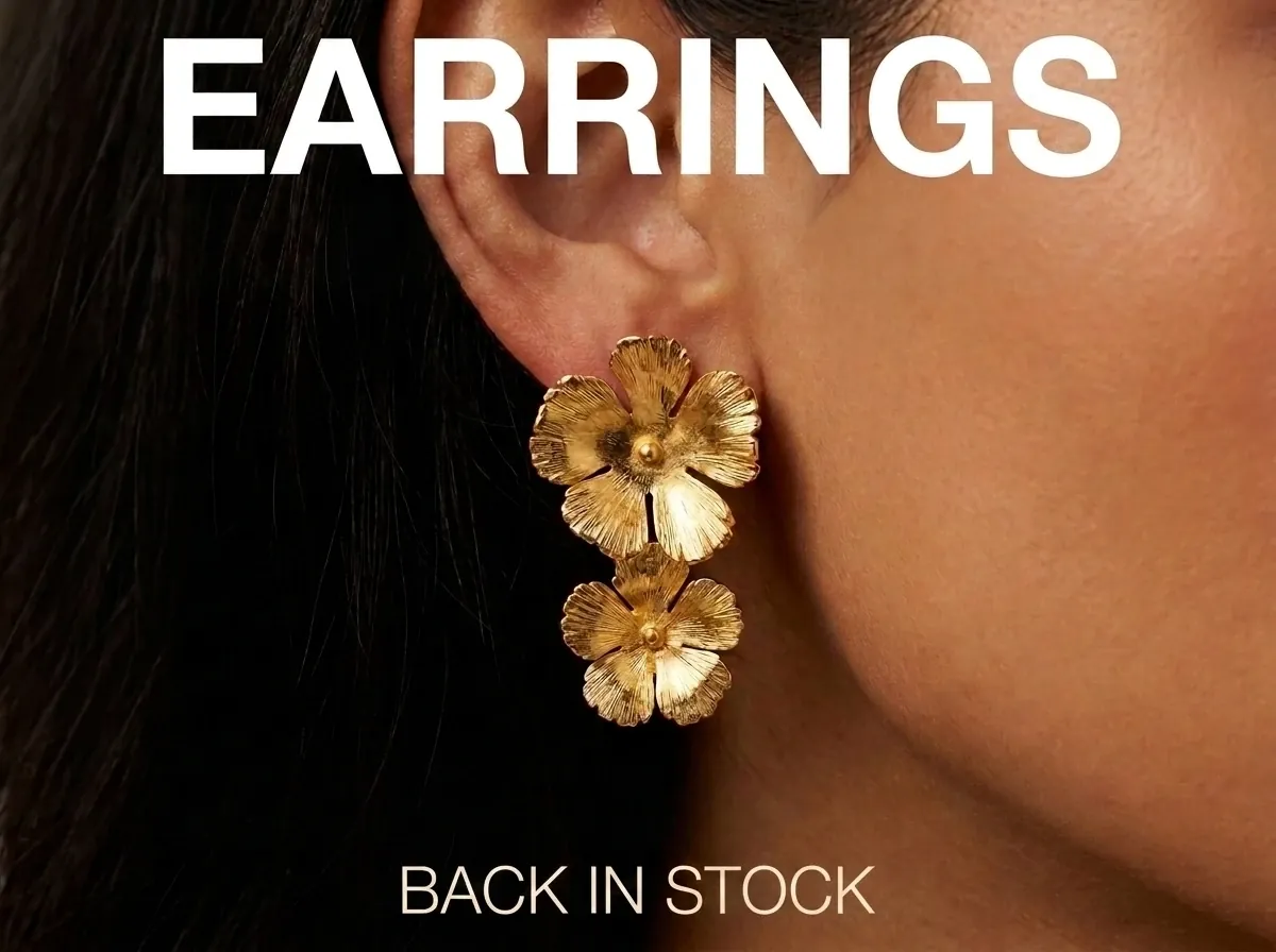 AI-generated Facebook jewelry ad: close-up of gold flower drop earrings worn on a model's ear with the headline EARRINGS BACK IN STOCK